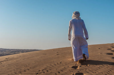 Man walking in oman desert 