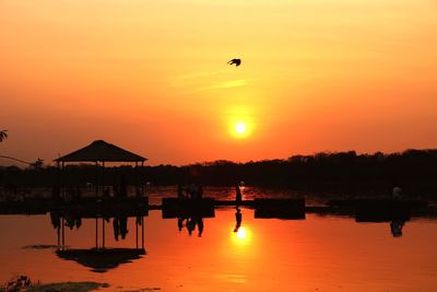 Scenic view of lake against orange sky