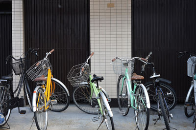 Bicycles parked on footpath by buildings in city