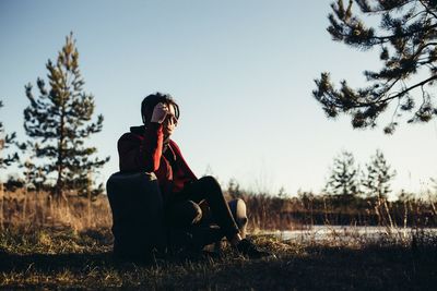 Man sitting on sofa against sky