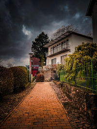 Street amidst trees and buildings against sky
