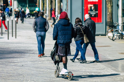 Rear view of people walking on street