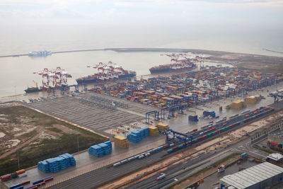 High angle view of cityscape by sea against sky