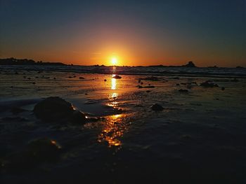 Scenic view of sea against clear sky during sunset