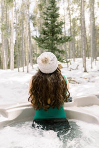 Woman from behind in a jacuzzi outdoors during winter