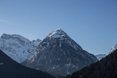 Scenic view of snowcapped mountains against clear blue sky