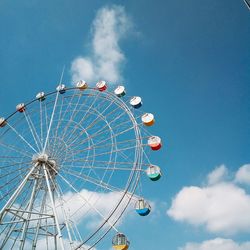 Low angle view of ferris wheel against blue sky