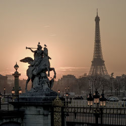 Statue at tuileries garden with eiffel tower against sky during sunset