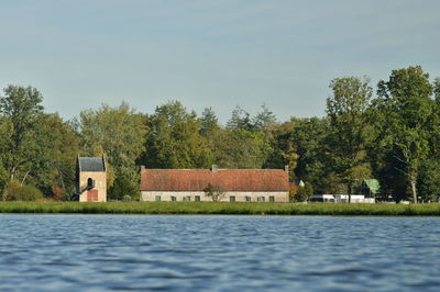 Scenic view of lake by building against sky