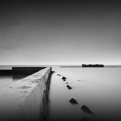 Pier by sea against sky during foggy weather