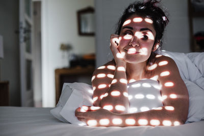 Smiling woman lying on bed at home