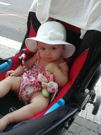 Portrait of cute baby girl sitting in stroller