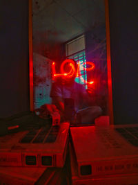Rear view of man standing in illuminated building
