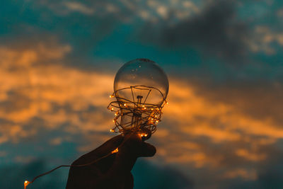 Close-up of person holding umbrella against sky