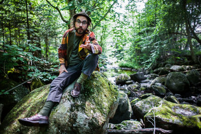 Young man standing on rock in forest