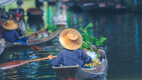 Rear view of men in boat at lake