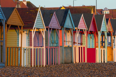 Multi colored houses on beach against buildings