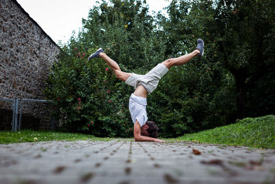 Young man exercising on footpath