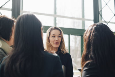 Mature businesswoman discussing with colleagues in conference meeting