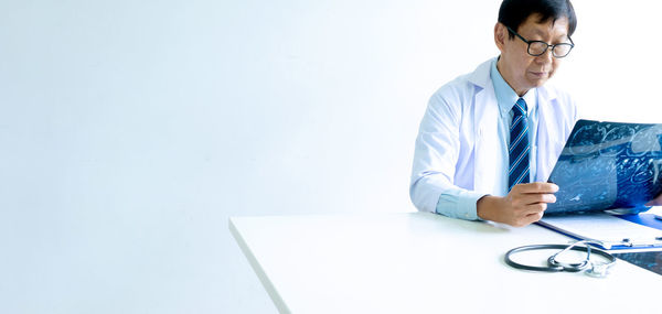 Midsection of man holding eyeglasses on table