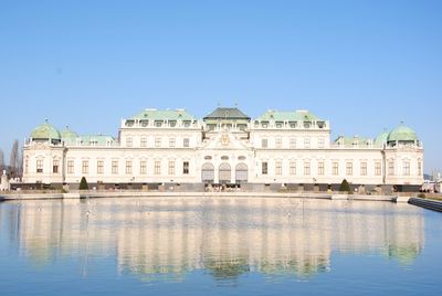 Belvedere castle with reflection on pond against clear sky