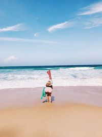 Boy on beach against sky