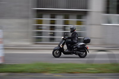 Blurred motion of man riding motorcycle on road