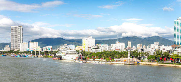 Buildings by sea against sky in city