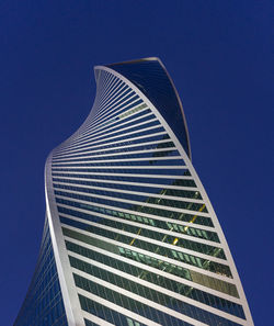 Low angle view of modern building against clear blue sky