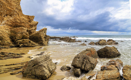 Rocks on beach against sky