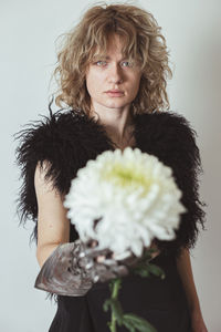 Close up curly haired model with dahlia in studio portrait picture