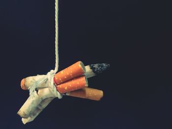 Close-up of cigarette smoking over black background