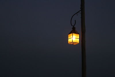 Low angle view of illuminated lighting equipment against sky