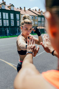 Midsection of woman holding umbrella in city