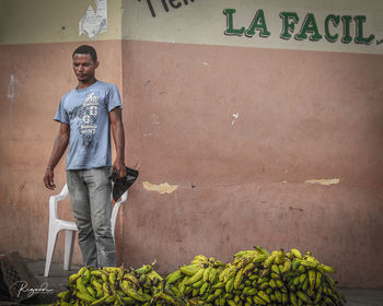 Portrait of young man standing against wall