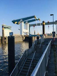 Pier over sea against clear blue sky