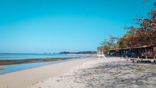 Scenic view of beach against clear blue sky