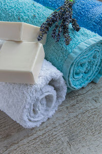 High angle view of soaps with rolled up towels and lavender flowers on table