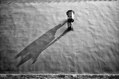Low angle view of gas light with shadow on wall