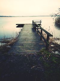 Wooden pier over sea against sky