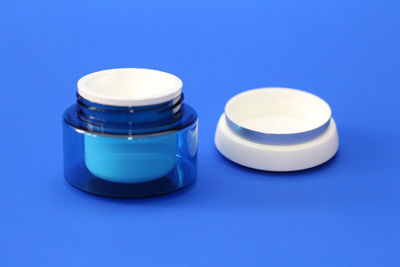 Close-up of jar on table against blue background