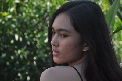 Close-up portrait of young woman looking away