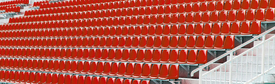 Folded red plastic chairs on a temporary tribune. selective focus