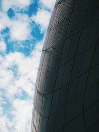 Low angle view of modern building against cloudy sky