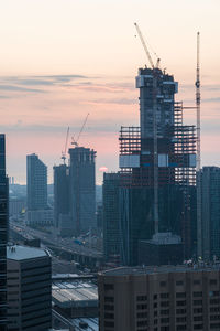 Modern buildings against sky at sunset