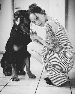 Young woman with dog sitting on floor at home