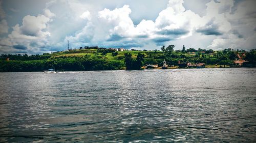 Scenic view of river against cloudy sky