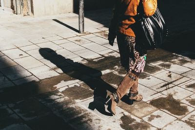 Low section of woman standing on footpath