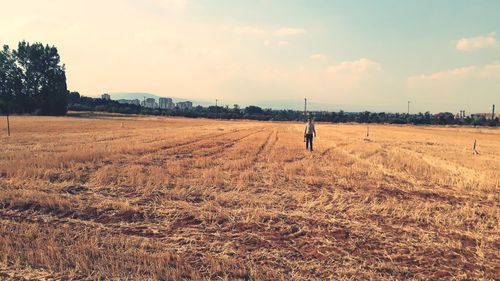 Man standing on field against sky