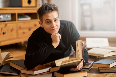 Portrait of young man sitting on table